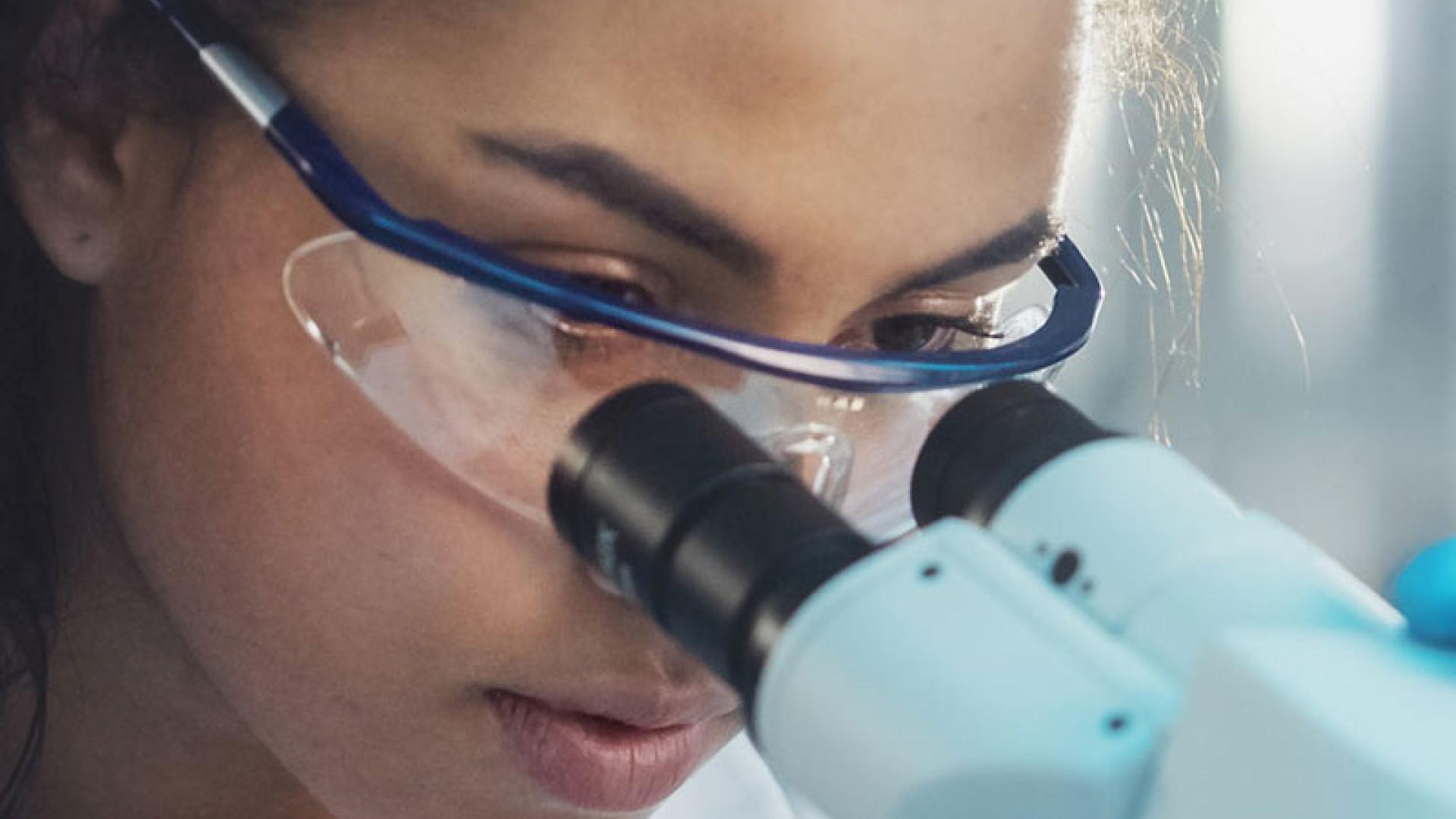 Student looking through microscope in a lab