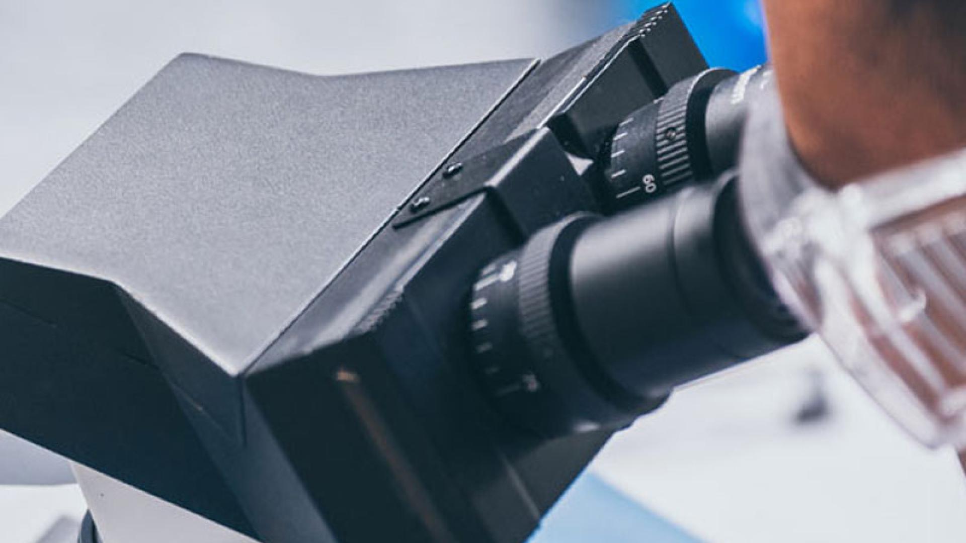 Medical Scientist using a Microscope