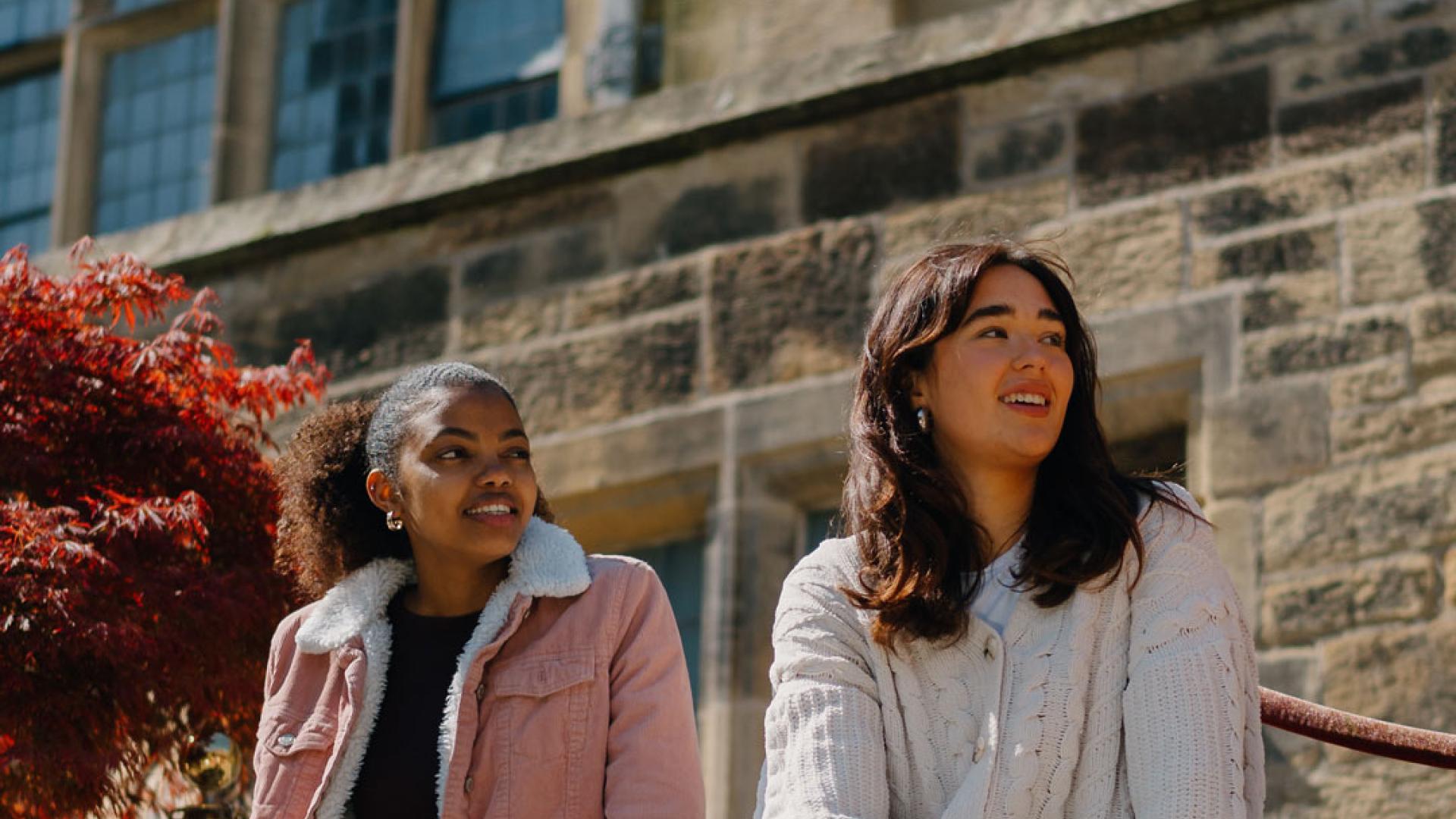 Group of students talking sitting in the inner quad of the Main University Building