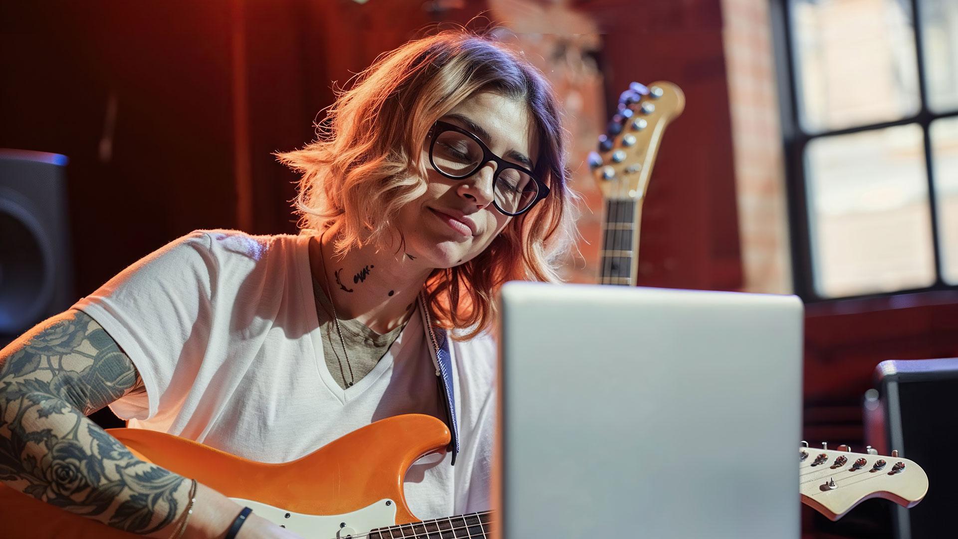 Girl with tattoos playing the guitar
