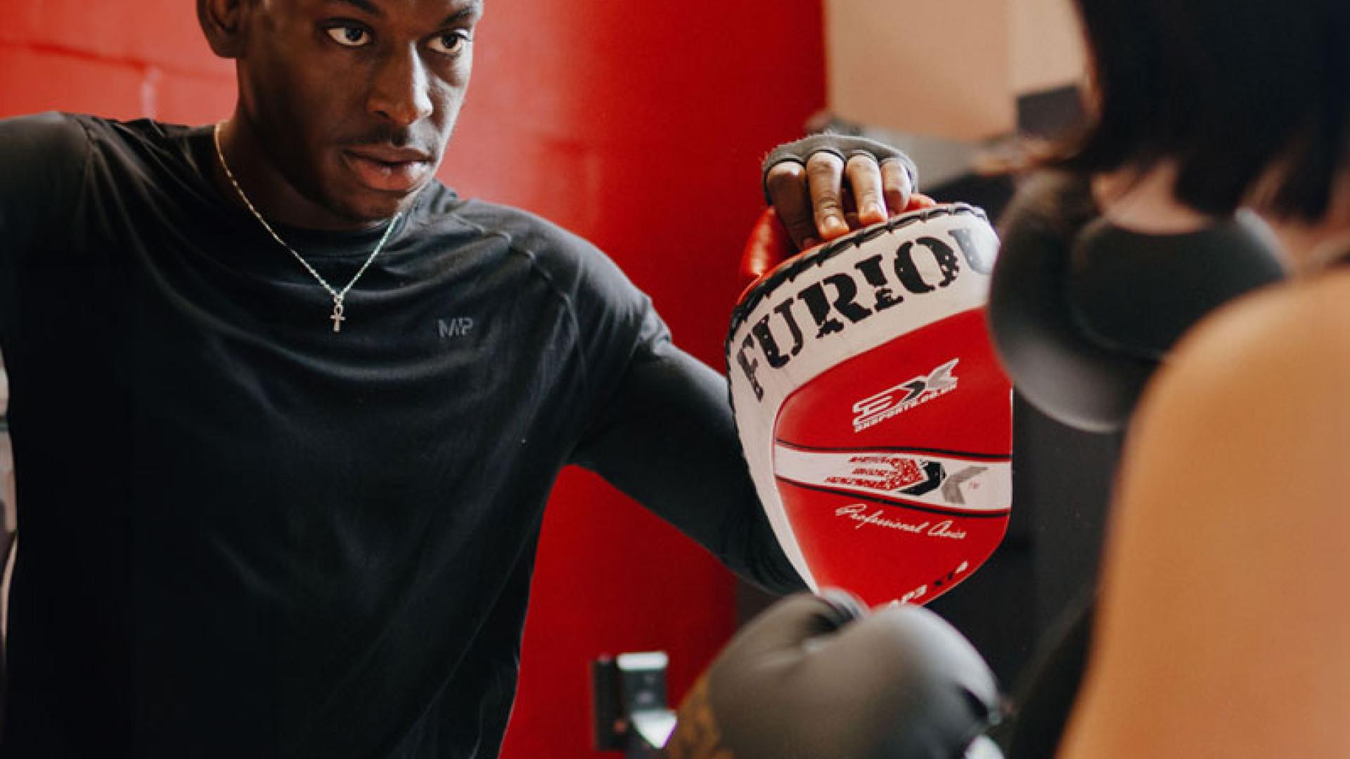 Boxing with coach in gym