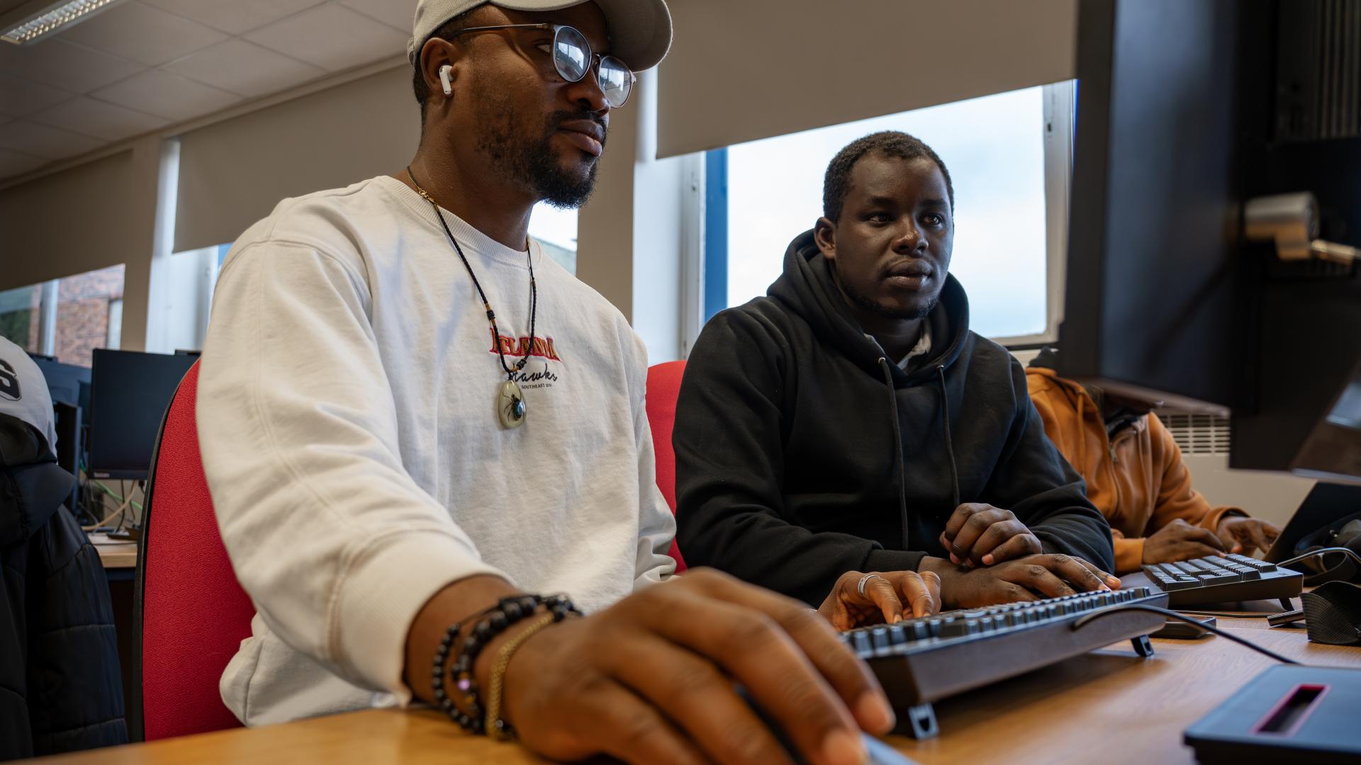 Two students looking at a screen of a PC
