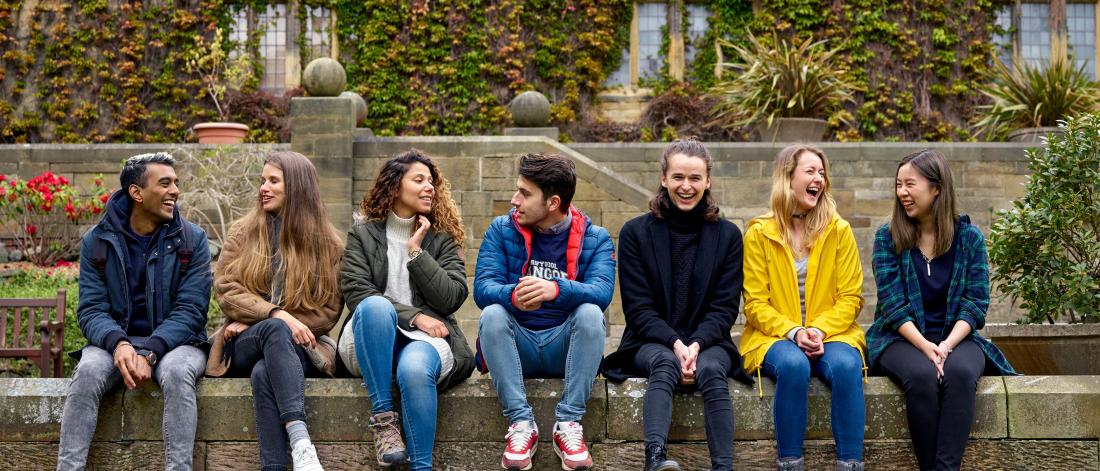 Students sitting on the wall in the inner quad of the Main Arts Building