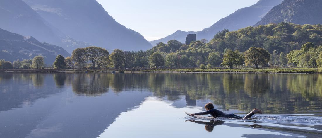 Myfyriwr ar Fwrdd Padlo ar Llyn Padarn yn Llanberis