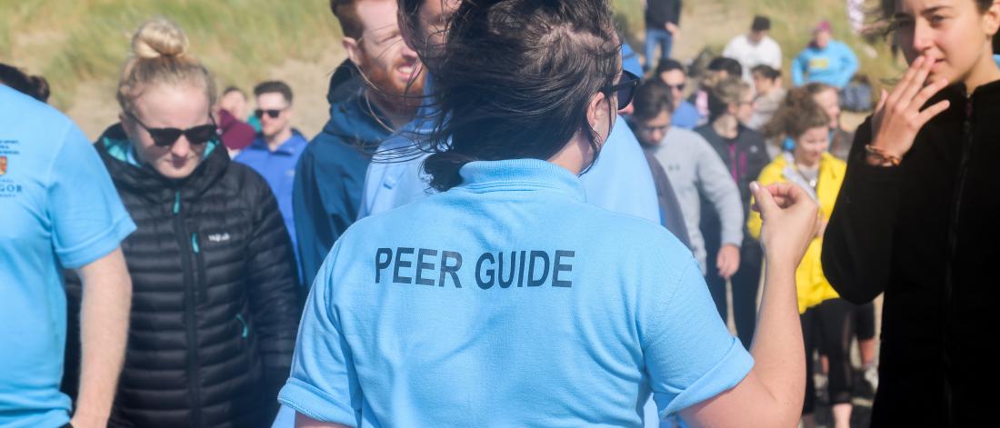 Peer guides helping students on a welcome week activity at the beach