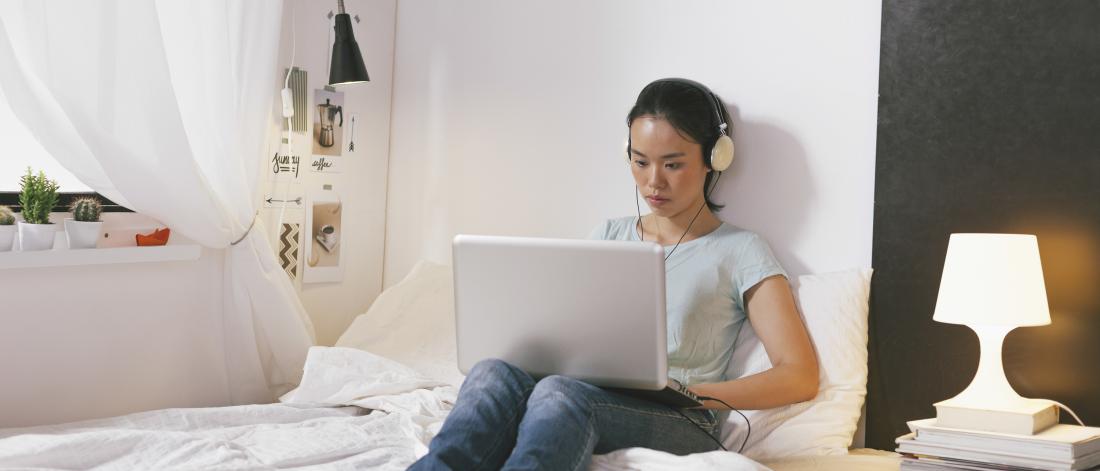 Student on laptop wearing headphones