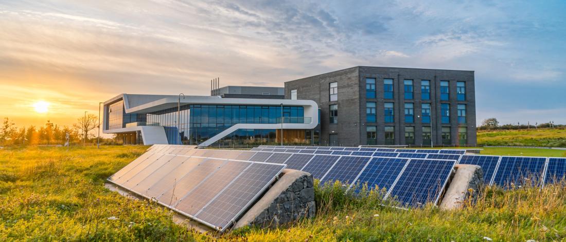 Modern building in field with solar panels in foreground