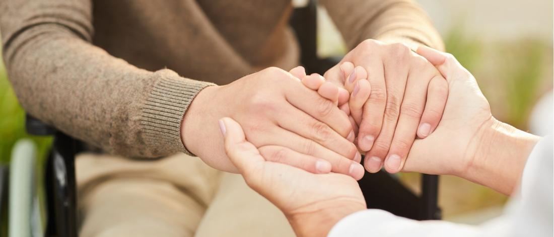 Carer holding patient's hands