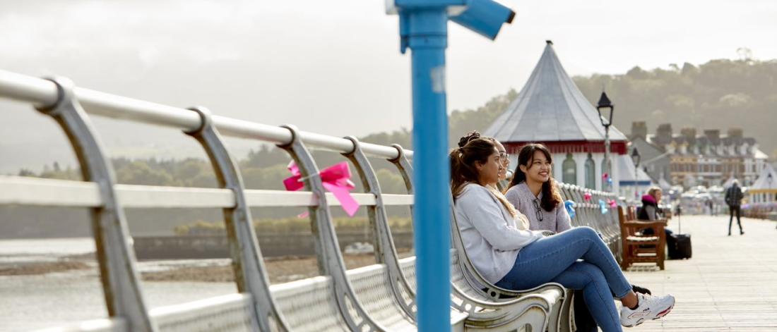 Students sitting on benches on Garth Pier