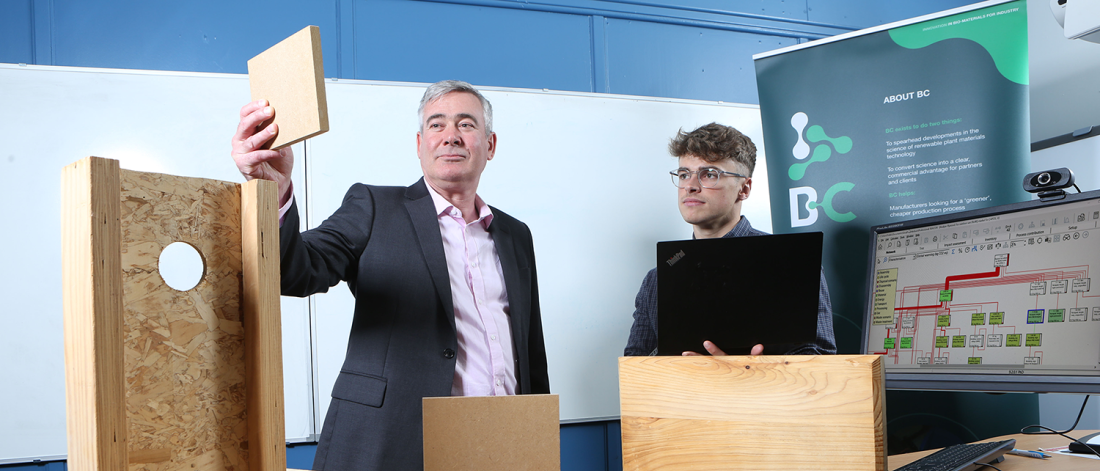 two people looking at timber with computers