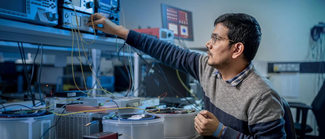 Man working with electronics in a lab.