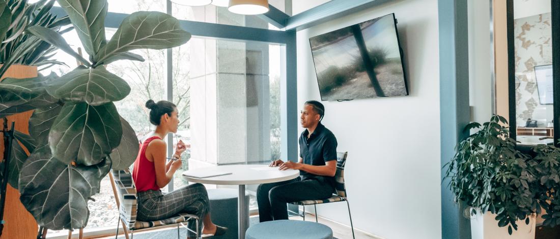 a picture of two people discussing sat down in an office enviroment