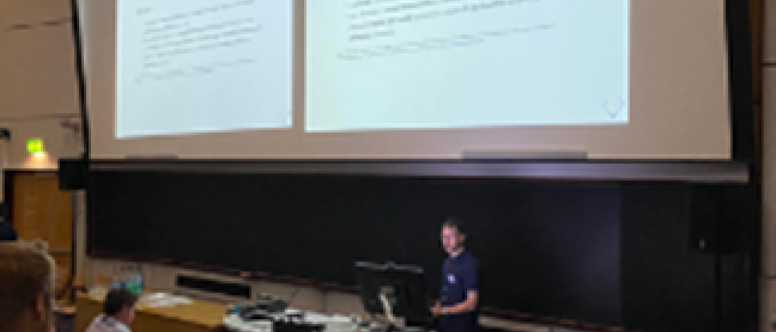 Dr Franck Vidal giving his oral presentation in a lecture room with students with a presentation showing