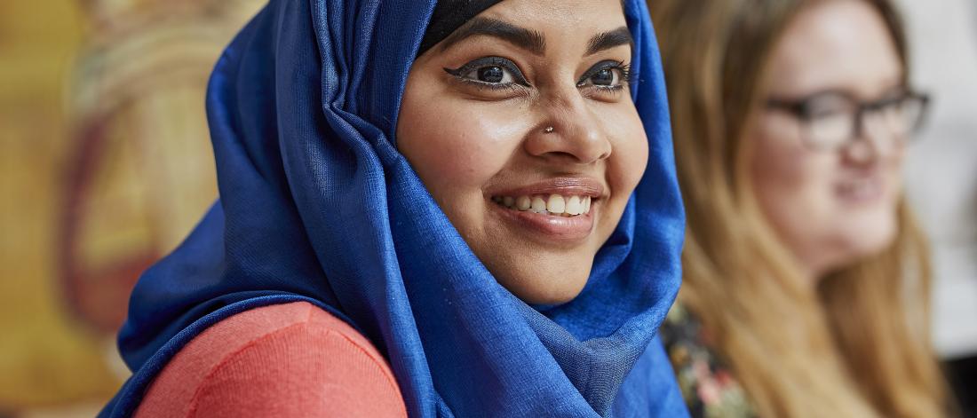 Female student with blue headscarf, smiling