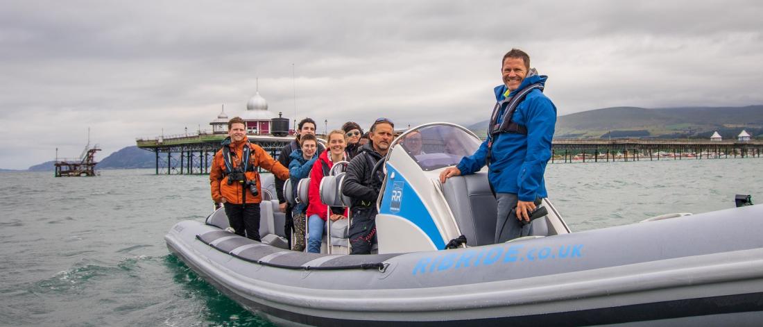 Steve Backshall a myfyrwyr ar daith cwch RibRide ar y Fenai