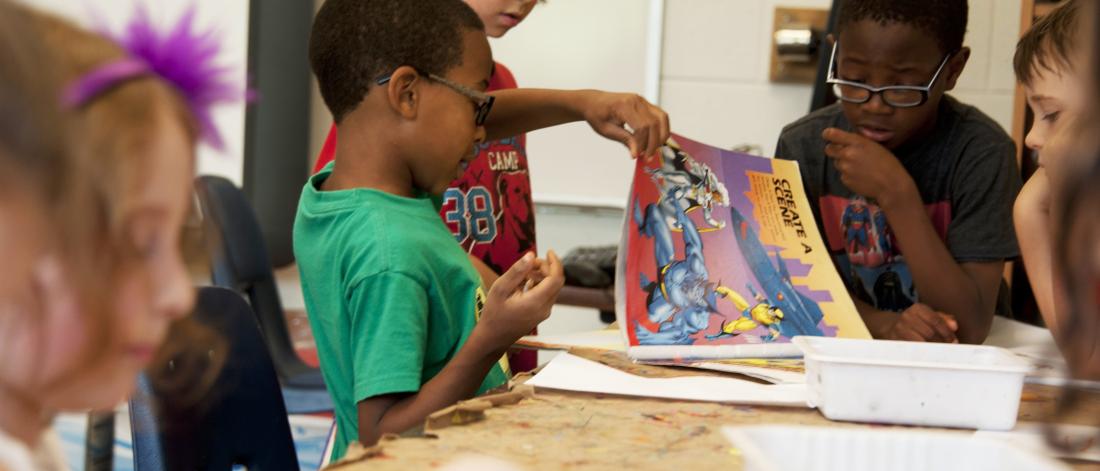 a classroom full of kids reading and drawing 