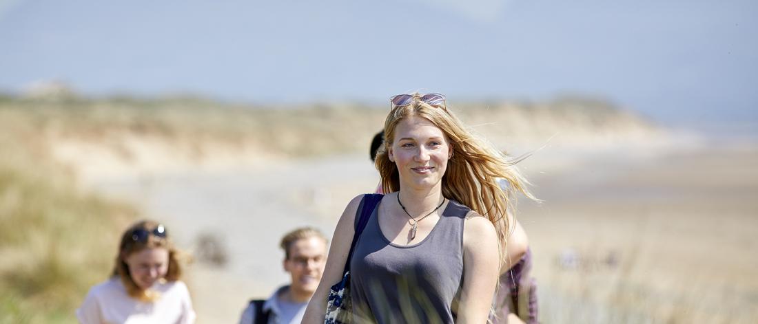Image of students at the beach smiling
