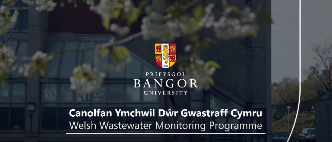 Teitl y fideo Canolfan Ymchwil Dŵr Gwastraff Cymru dros gefndir o adeilad Brambell Prifysgol Bangor