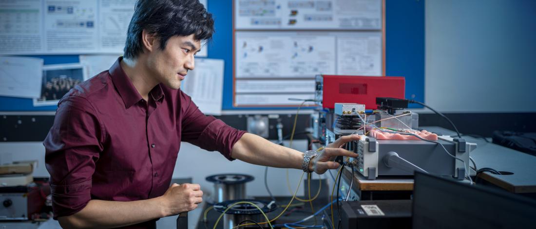 Man in laboratory with hand reaching technical equipment