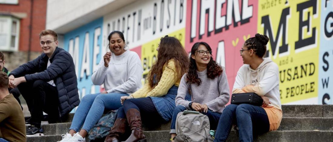 Students sitting on the steps outside Pontio