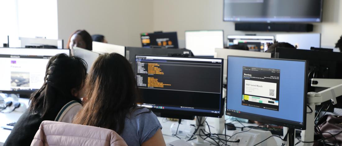 Two students looking at databases in the new trading floor