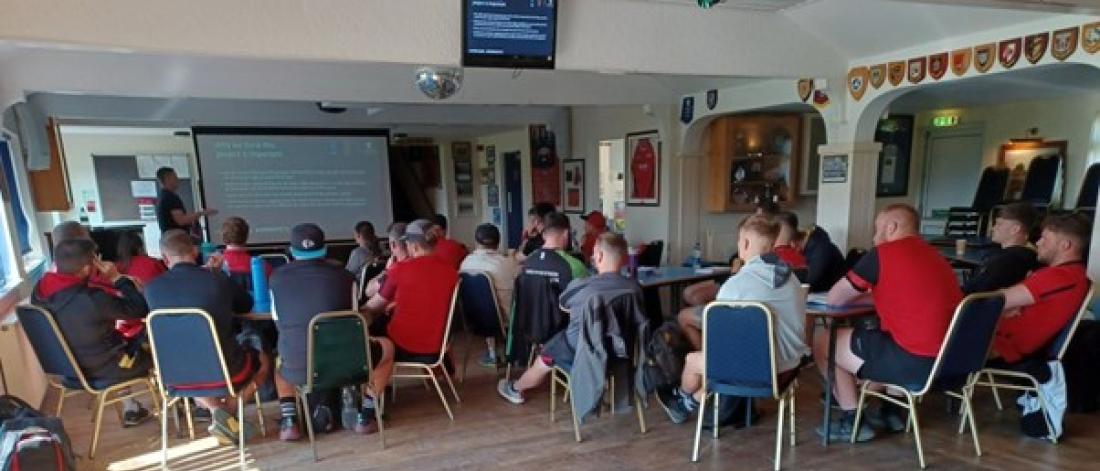 Group of people taking part in the Hub Officer engagement. All sitting looking at a presenter and a screen.