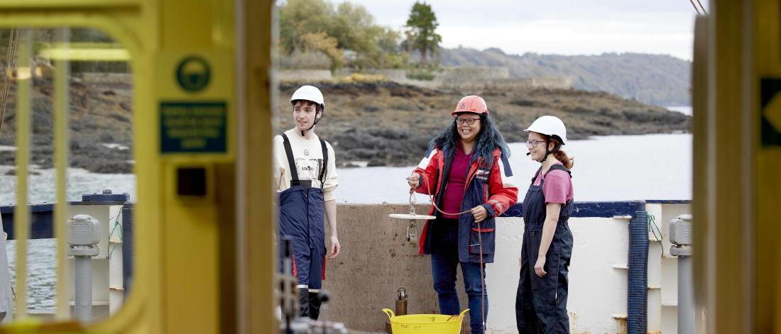 Three students talking on the deck of the Prince Madog