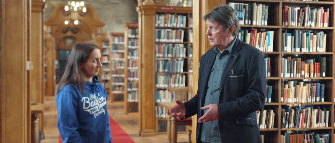 Thumbnail image showing image of student and historian talking in Shankland Library