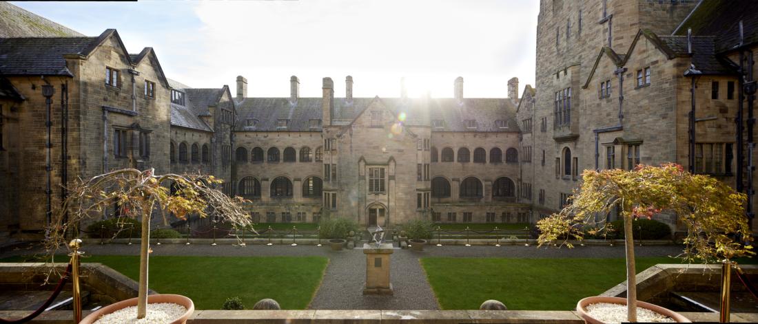 Main Arts quad in Autumn with the sun shining behind the rooftop