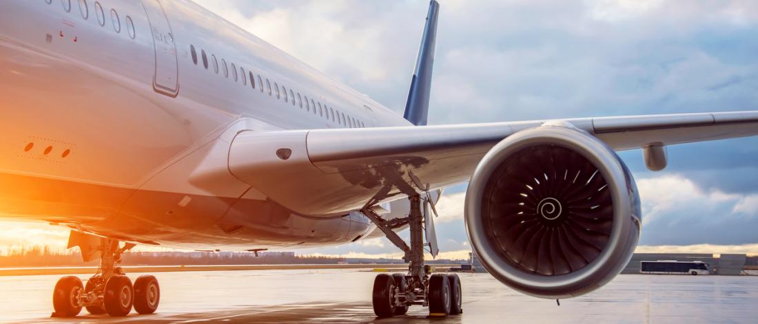 Fuselage of a passenger wide-body airliner, view of the landing gear of the engine and wing in the evening during the evening light of the sun
