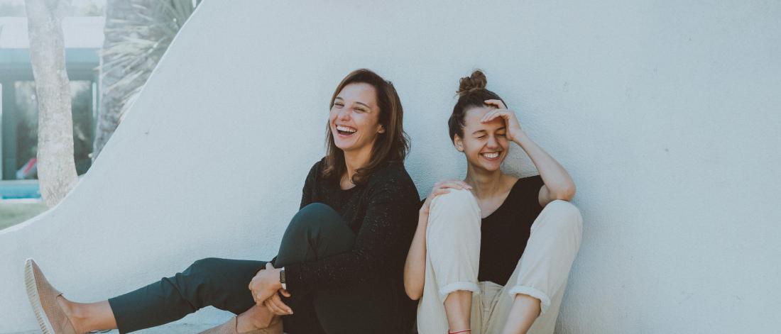 Two women sat together laughing