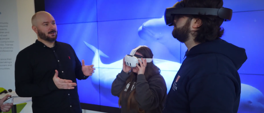 Dr Llyr ap Cennydd with two students wearing a VR headset