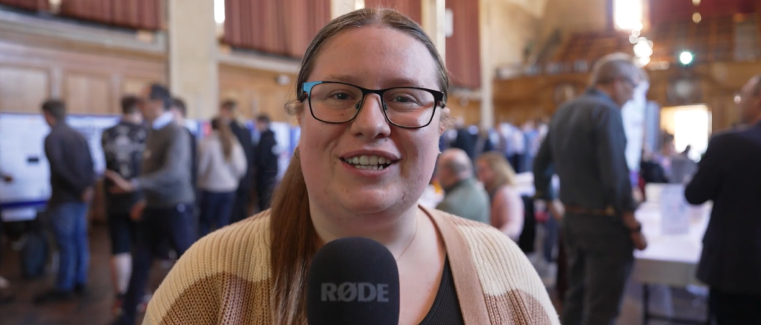 Student, Catty Langford, holding a microphone reporting from the EXPO