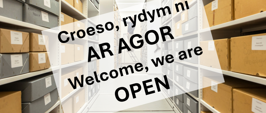 Sign saying: Welcome we are open against an archives backdrop