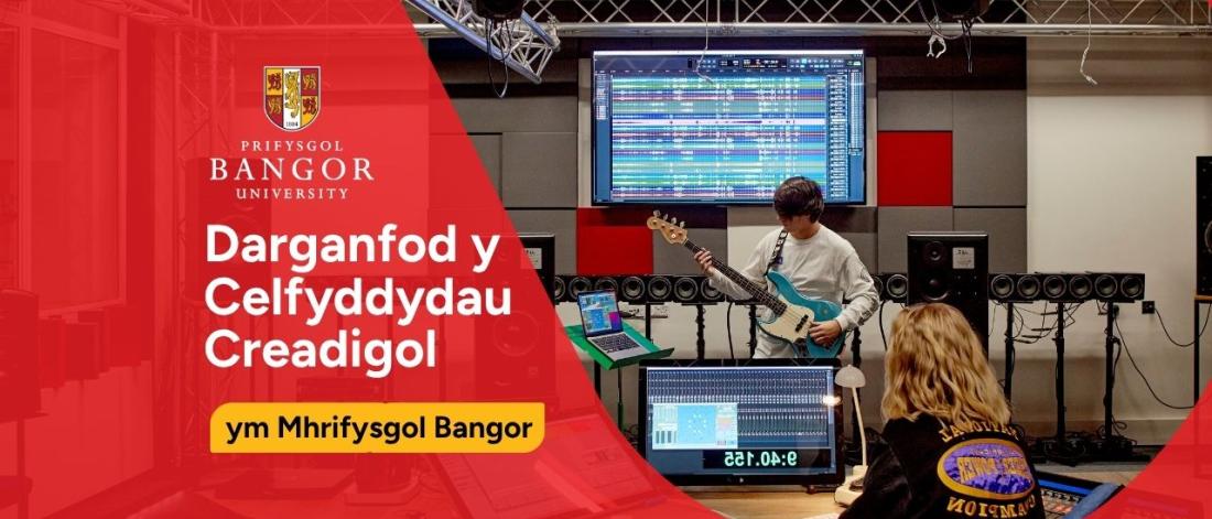 Two students using equipment in a music studio at Bangor University.