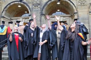 A group of students throwing their caps in their air after their graduation ceremony