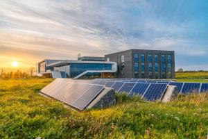 Modern building in field with solar panels in foreground