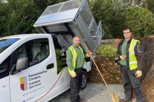 An electric vehicle with members of the operations team