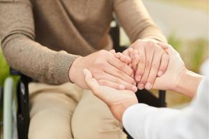 Carer holding patient's hands