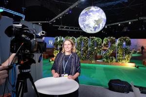 Yr Athro Julia Jones yn sefyll o flaen camera yn COP26