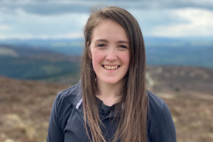 Sophie Harrison yn yr awyr agored, yn gwenu i'r camera