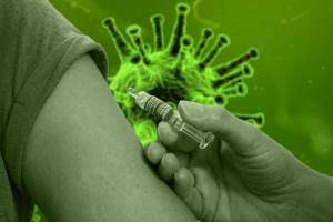 A hand inocculates an arm with vaccine in background is image of coronavirus cell all has a green wash
