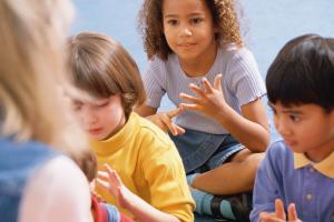 Three children counting with an adult