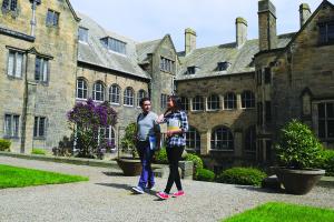 Image of two students walking in the inner quad, main arts building
