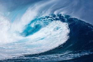 a large blue breaking wave about to topple