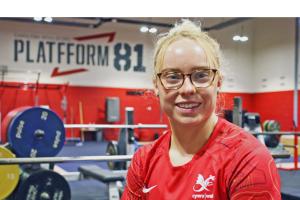 Picture of Catrin Jones wearing a red t-shirt in the weightlifting training facility