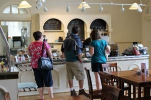 Three people in a queue in a tea room