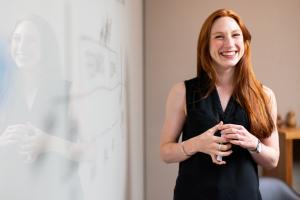 woman next to whiteboard