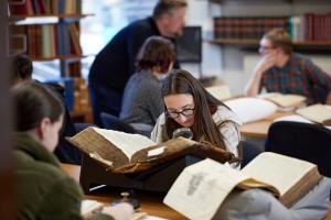 Students looking at books in the university archive 
