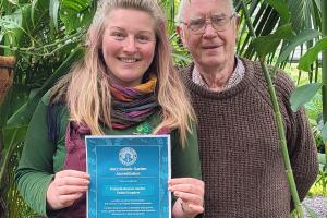 Image of Natalie holding a certificate with Paul